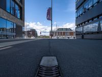 a very empty street in front of some buildings with a street flag flying in the sky