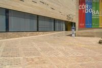 an empty street that is lined with brick blocks and a small parking meter on the right