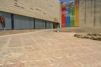 an empty street that is lined with brick blocks and a small parking meter on the right