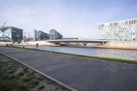 an empty street and bridge are next to the water in front of buildings in europe