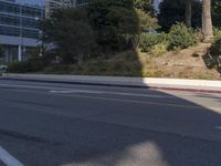 an empty street with a building on the hill in the background and a red line painted across