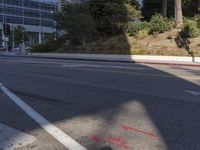 an empty street with a building on the hill in the background and a red line painted across