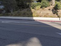 an empty street with a building on the hill in the background and a red line painted across