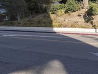 an empty street with a building on the hill in the background and a red line painted across