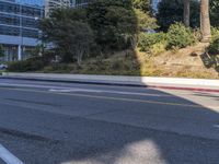 an empty street with a building on the hill in the background and a red line painted across