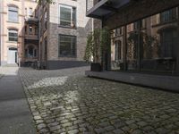 there is an empty street between two buildings near by bicycles and bicycles parked at the street