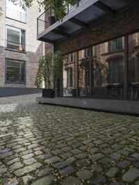there is an empty street between two buildings near by bicycles and bicycles parked at the street