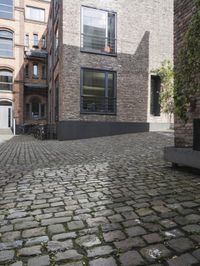 there is an empty street between two buildings near by bicycles and bicycles parked at the street