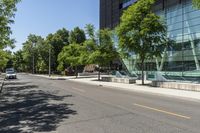 empty street with buildings along side and trees on both sides of the road in front