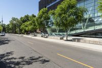 empty street with buildings along side and trees on both sides of the road in front