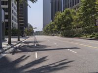 an empty street with buildings and trees on both sides of the road on the other side