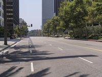 an empty street with buildings and trees on both sides of the road on the other side