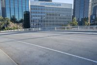the street is empty in a big city with tall buildings behind it and a pedestrian walking across