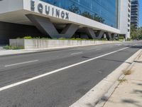 an empty street near a building next to a sidewalk that says mofuk at the top