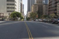 the street is empty except for traffic and trees in the area of the city,