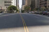 the street is empty except for traffic and trees in the area of the city,