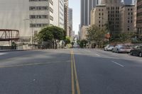 the street is empty except for traffic and trees in the area of the city,