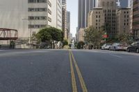 the street is empty except for traffic and trees in the area of the city,