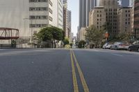 the street is empty except for traffic and trees in the area of the city,