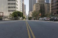 the street is empty except for traffic and trees in the area of the city,