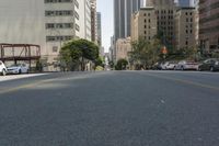 the street is empty except for traffic and trees in the area of the city,