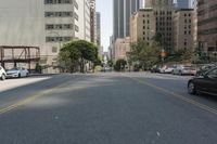 the street is empty except for traffic and trees in the area of the city,