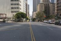 the street is empty except for traffic and trees in the area of the city,