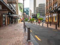 a view down an empty street lined with buildings and shopping shops in the background are tall buildings