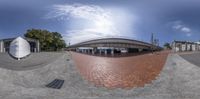 a fisheye lens image of an empty street in a city square at the time