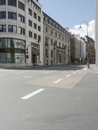 an empty street next to a tall building with many windows that have signs on each corner