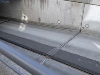 a close up view of an empty street with concrete walls and metal bars and supports