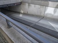 a close up view of an empty street with concrete walls and metal bars and supports