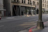an empty street corner with buildings on either side of the road and an intersection sign that reads no parking