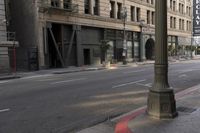 an empty street corner with buildings on either side of the road and an intersection sign that reads no parking
