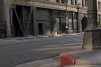 an empty street corner with buildings on either side of the road and an intersection sign that reads no parking