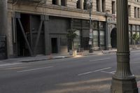 an empty street corner with buildings on either side of the road and an intersection sign that reads no parking