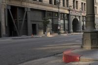 an empty street corner with buildings on either side of the road and an intersection sign that reads no parking