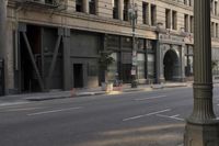 an empty street corner with buildings on either side of the road and an intersection sign that reads no parking