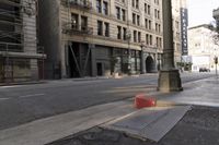 an empty street corner with buildings on either side of the road and an intersection sign that reads no parking