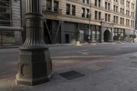 an empty street corner with buildings on either side of the road and an intersection sign that reads no parking