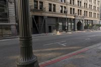 an empty street corner with buildings on either side of the road and an intersection sign that reads no parking