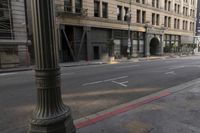 an empty street corner with buildings on either side of the road and an intersection sign that reads no parking