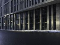 an empty street is covered by ice in front of the office building at night time