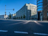 an empty street at a crosswalk in front of some buildings and a bus stop light