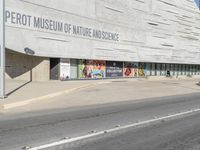 an empty street in front of a museum of nature and science sign on a building