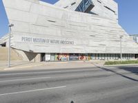 an empty street in front of a museum of nature and science sign on a building