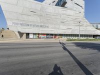 an empty street in front of a museum of nature and science sign on a building