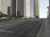 a view of the empty street with several arrows painted on it and tall buildings in the background