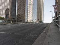 a view of the empty street with several arrows painted on it and tall buildings in the background