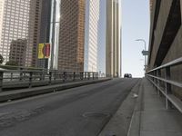 a view of the empty street with several arrows painted on it and tall buildings in the background